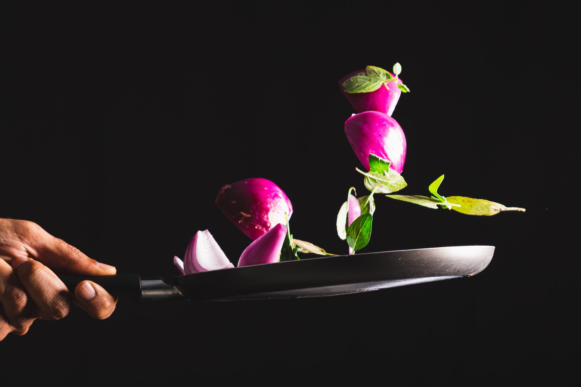 Chef plating a modern dish with neon-lit kitchen background